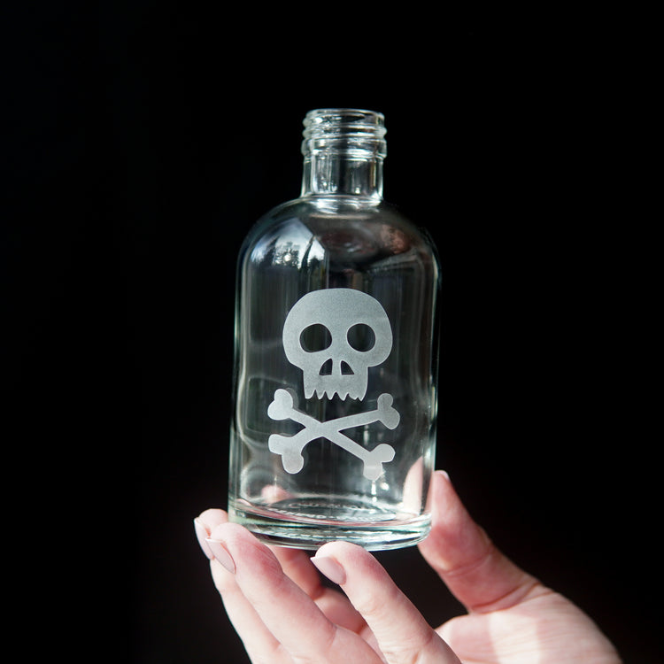 skull and crossbones etched onto a glass bottle