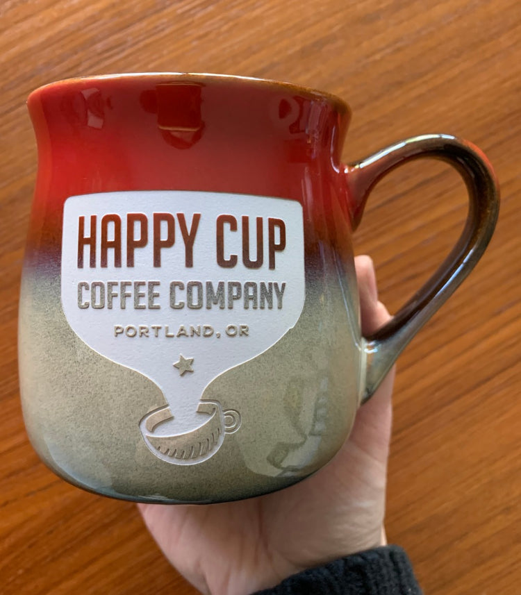 Happy Cup Coffee Company logo with "Portland, OR" underneath the company name, engraved on a red and beige mug
