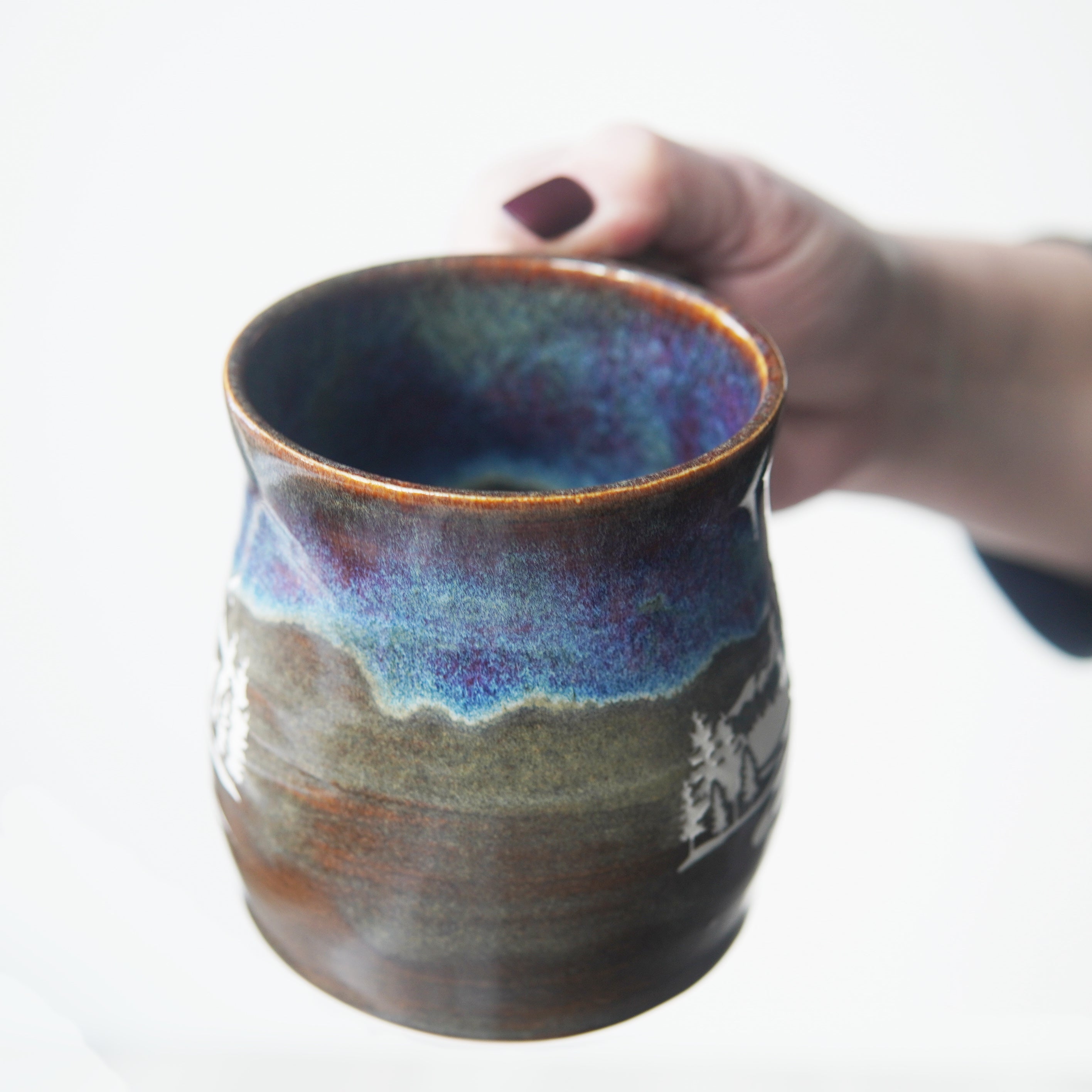 Mountain mug in dusk drippy purple, blue, and brown glaze, showing the colorful inside