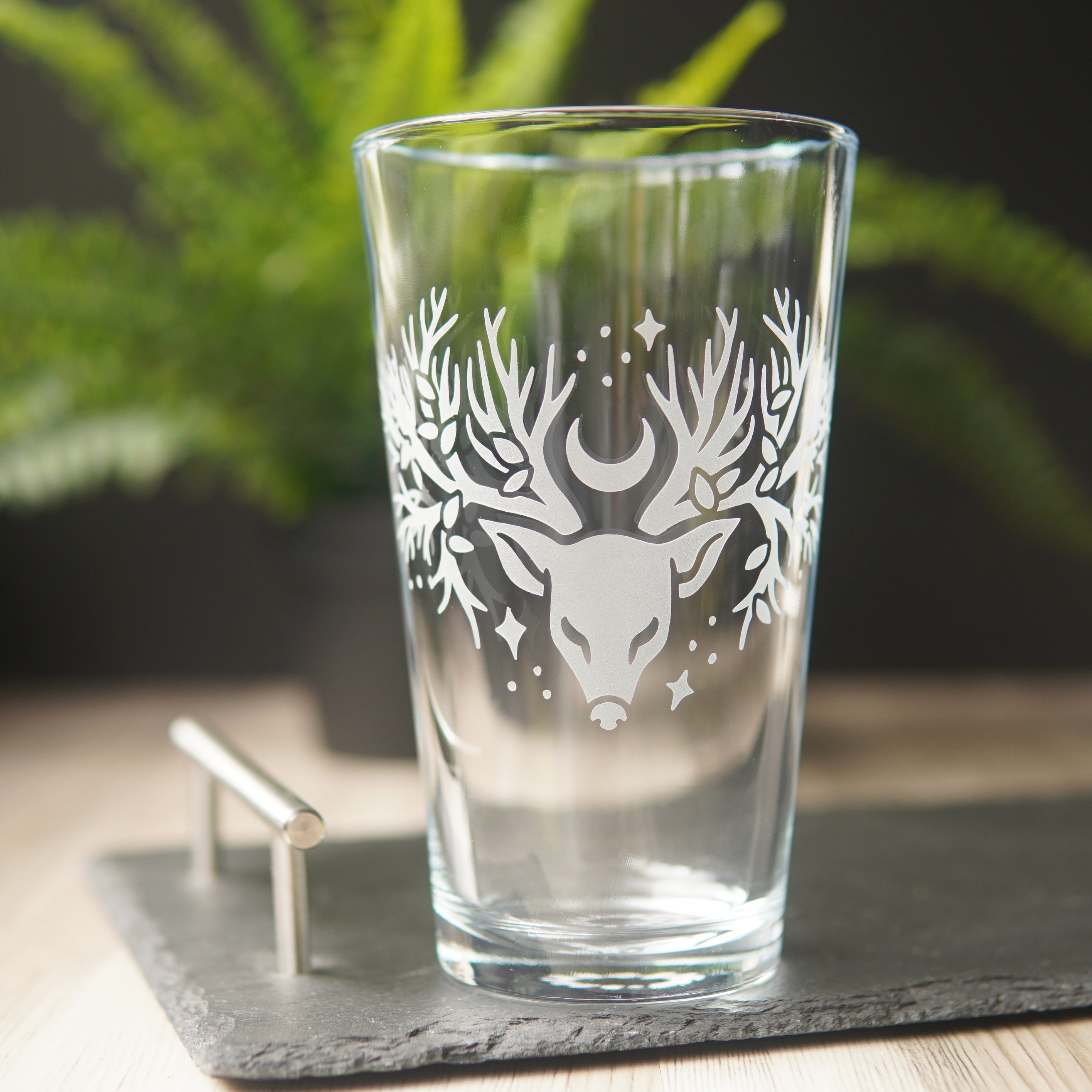 pint glass etched with a deer head whose antlers are tree branches