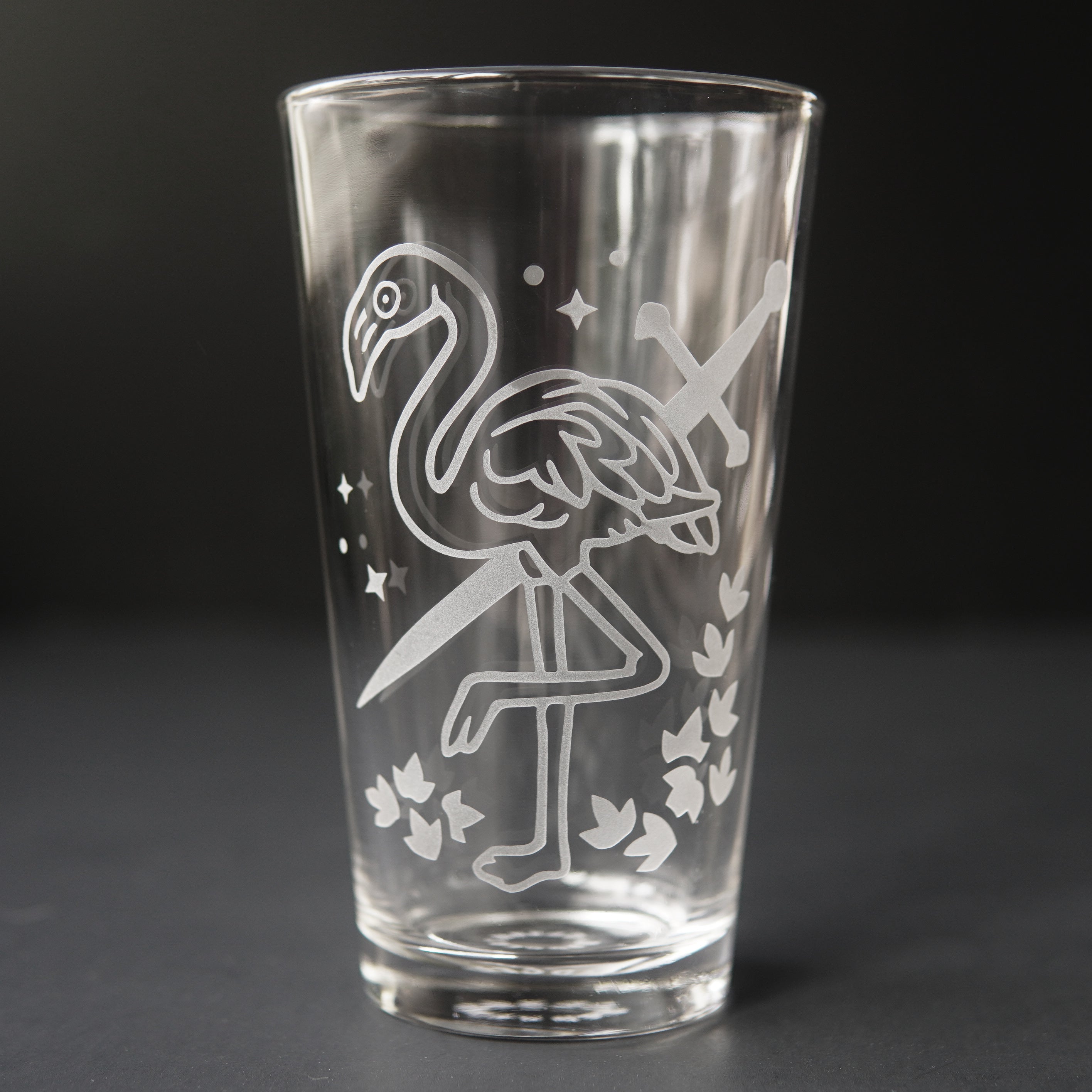 pint glass etched with a flamingo and sword