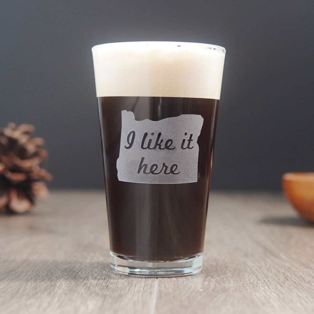 pint glass etched with the state of Oregon and the words "I like it here" inside the state