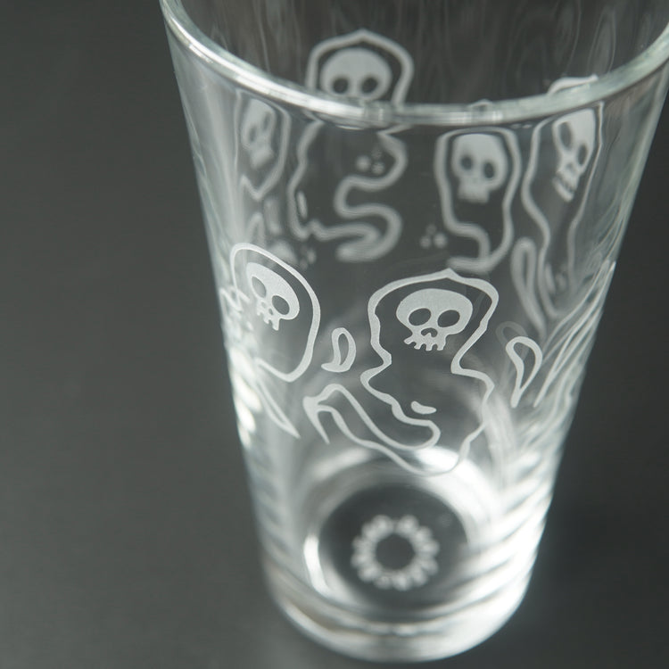 pint glass etched all over with ghosts with skull faces