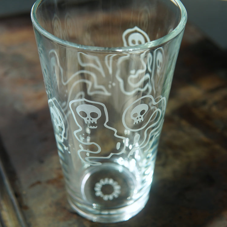 pint glass etched all over with ghosts with skull faces