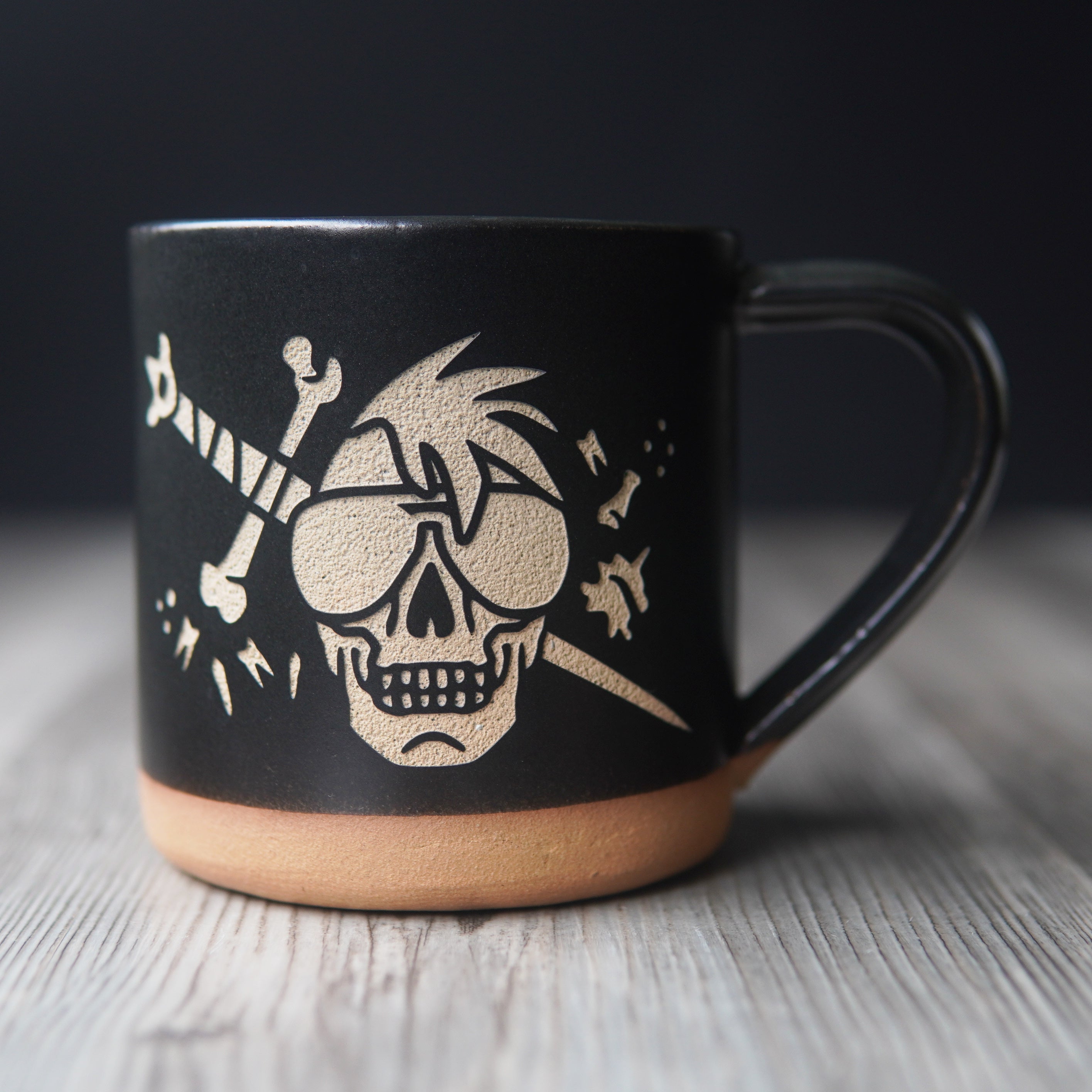 skull wearing aviator sunglasses with a bone sword and floating teeth, engraved onto a mug
