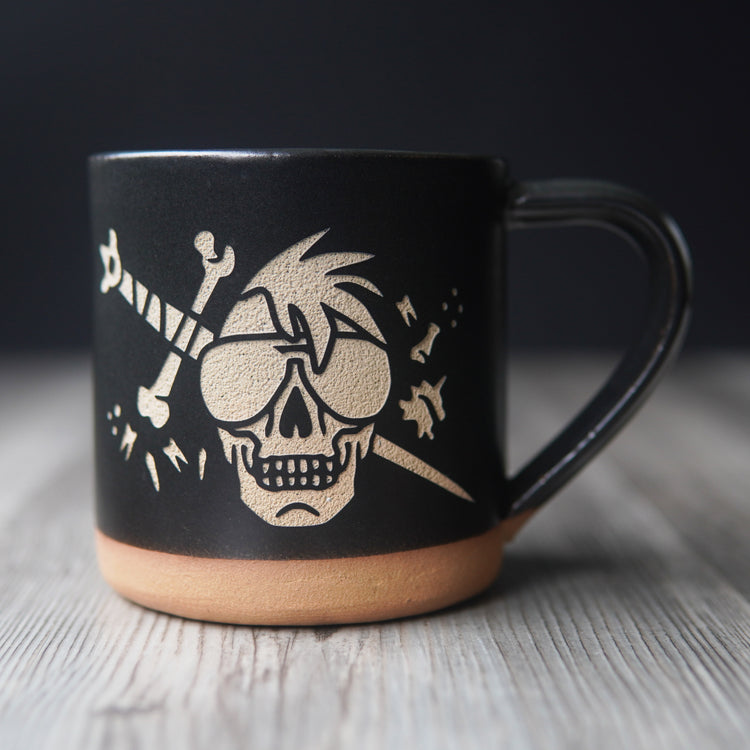 skull wearing aviator sunglasses with a bone sword and floating teeth, engraved onto a mug