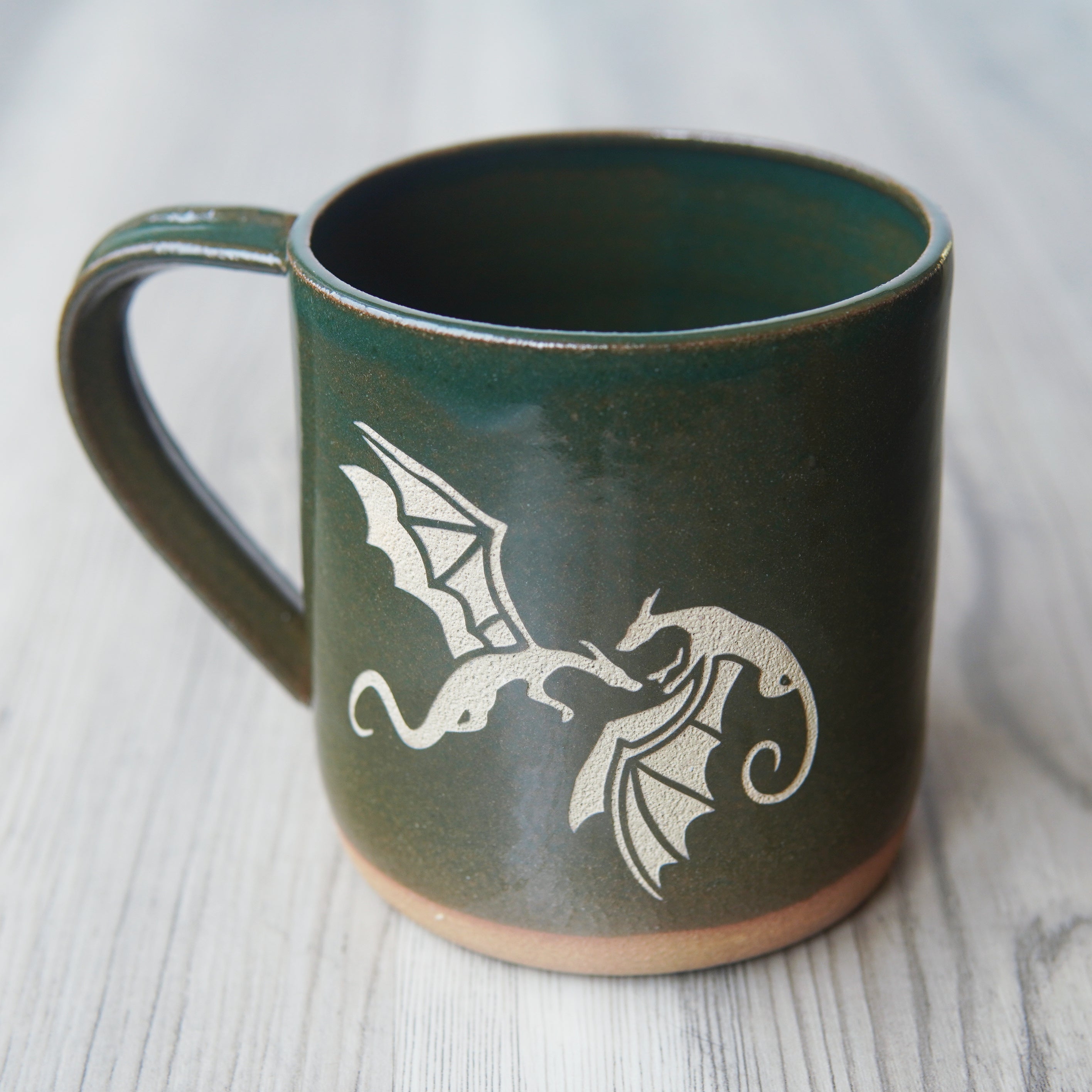 dragons engraved on a dark green mug