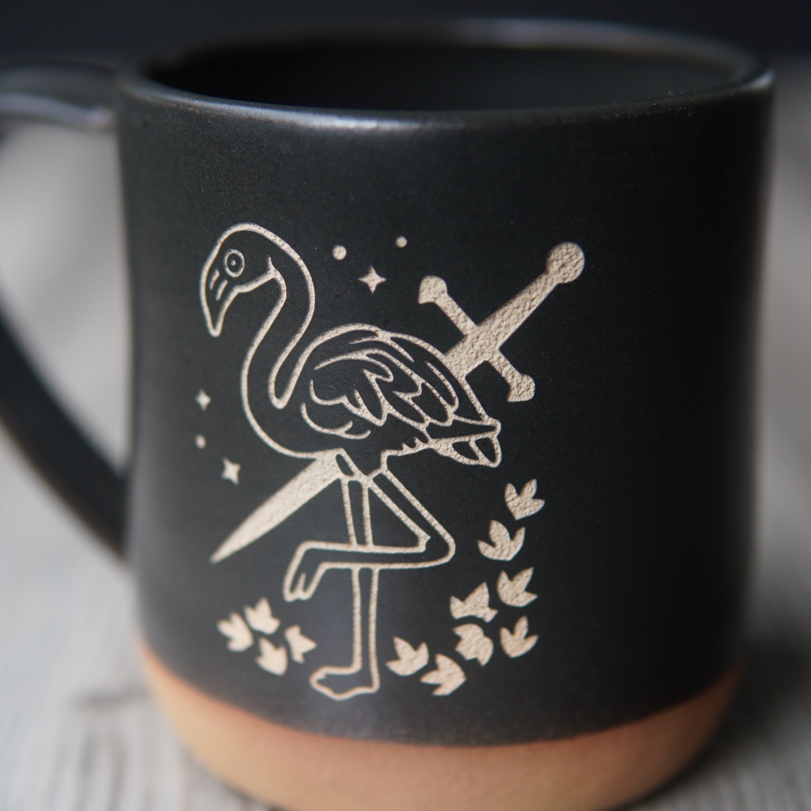 black flamingo with a sword mug, close up