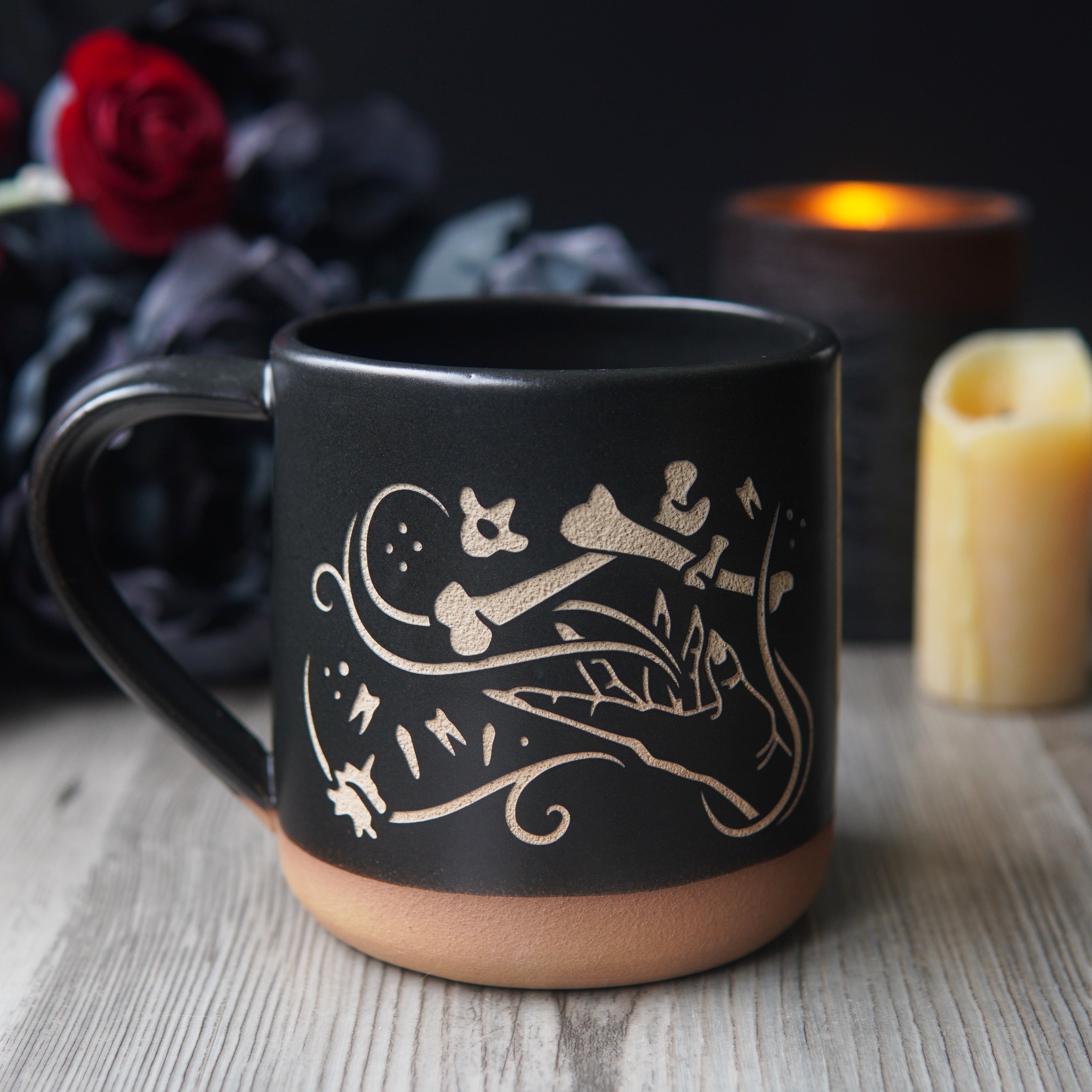 necromancer hand with bones and floating teeth, engraved onto a mug