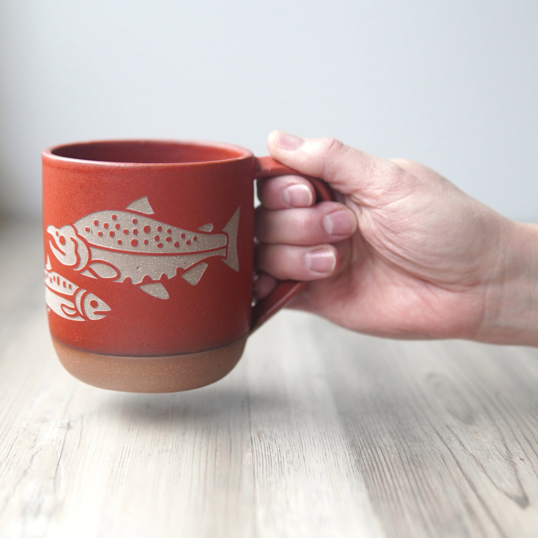 paprika red salmon mug, held by a hand