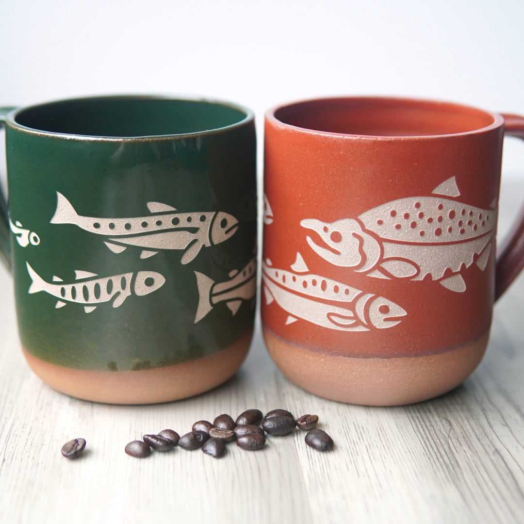 Salmon lifecycle mugs in pine green and paprika red