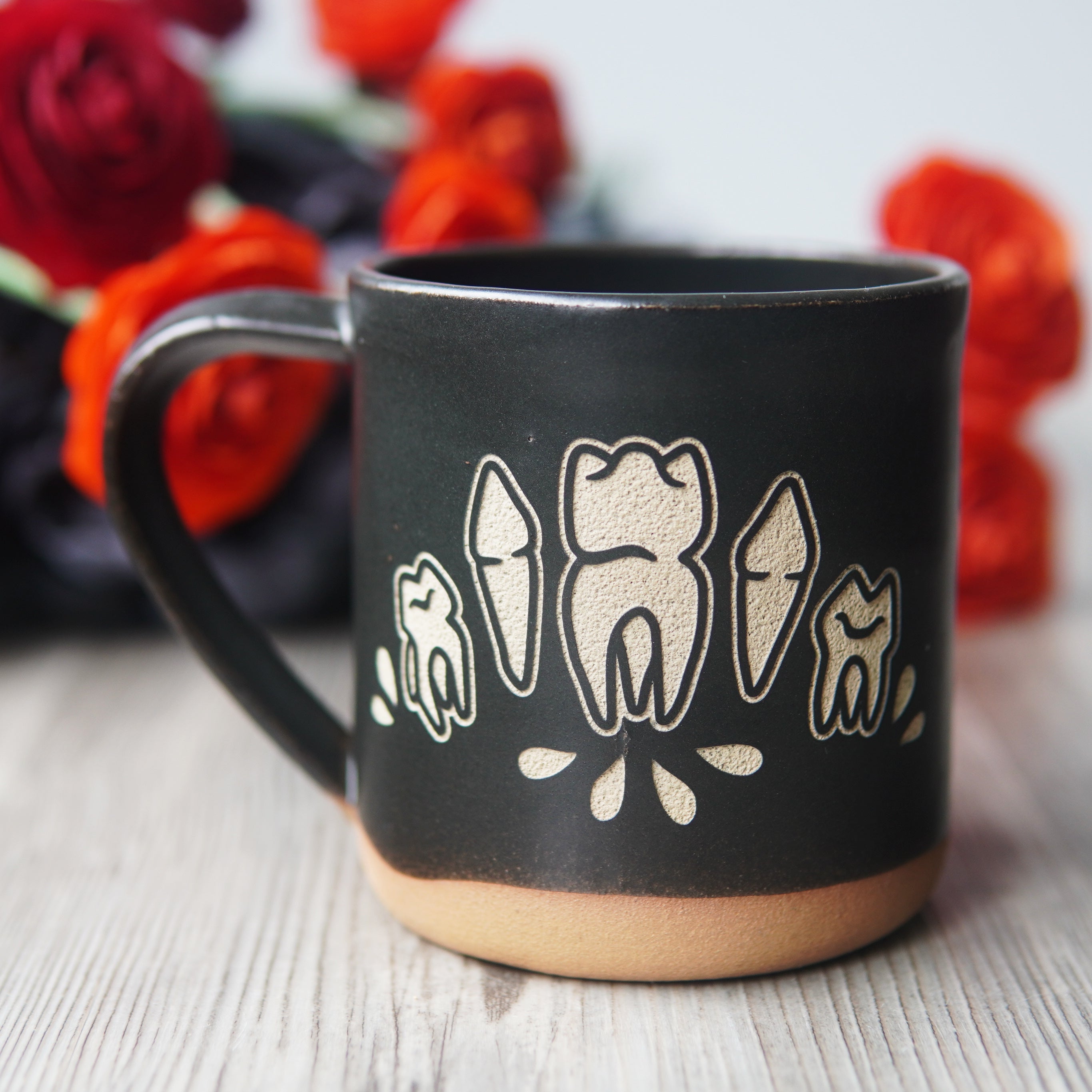 teeth and blood droplets engraved onto a black mug