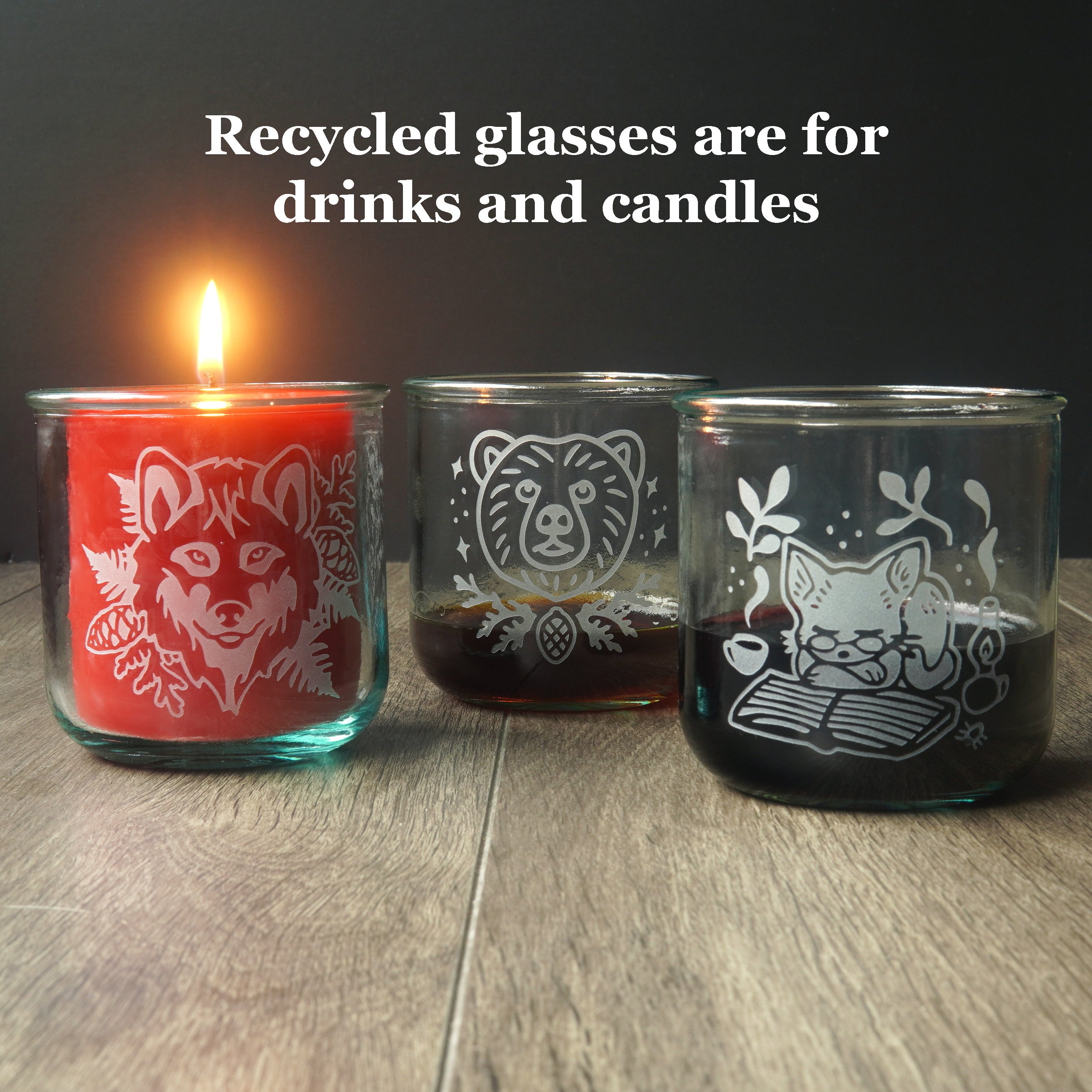 text reads: "recycled glasses are for drinks and candles" above three short etched tumblers. One has a lit candle inside it, the others have dark liquids inside.