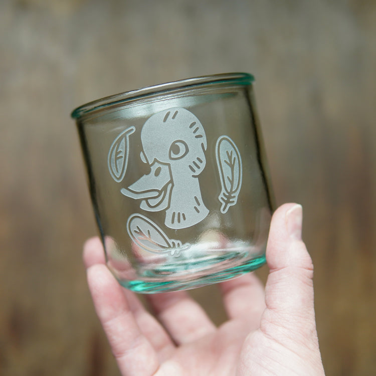 Duck engraved short glass, held in a hand