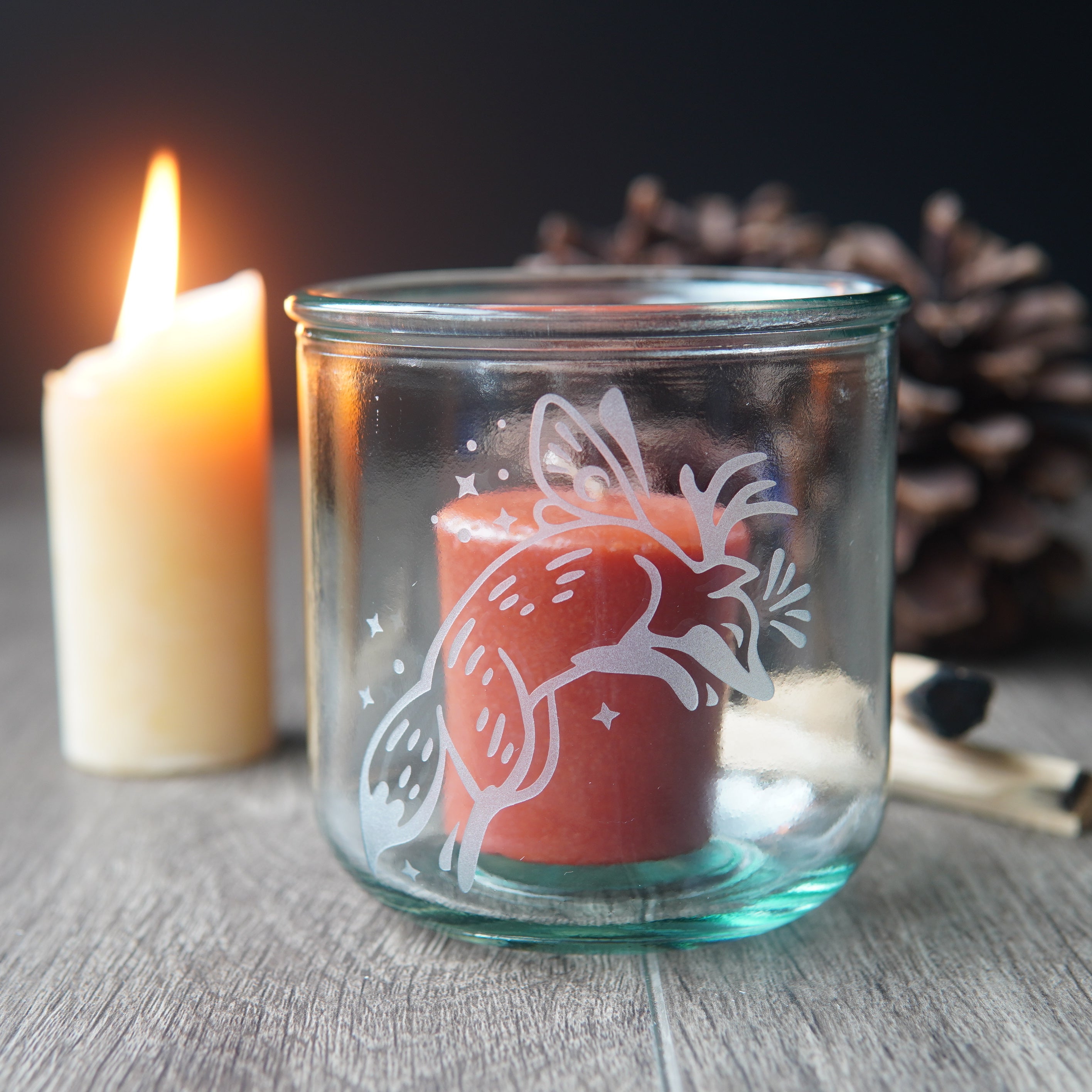 Fox fairy with wings and antlers etched onto a short glass with a votive candle