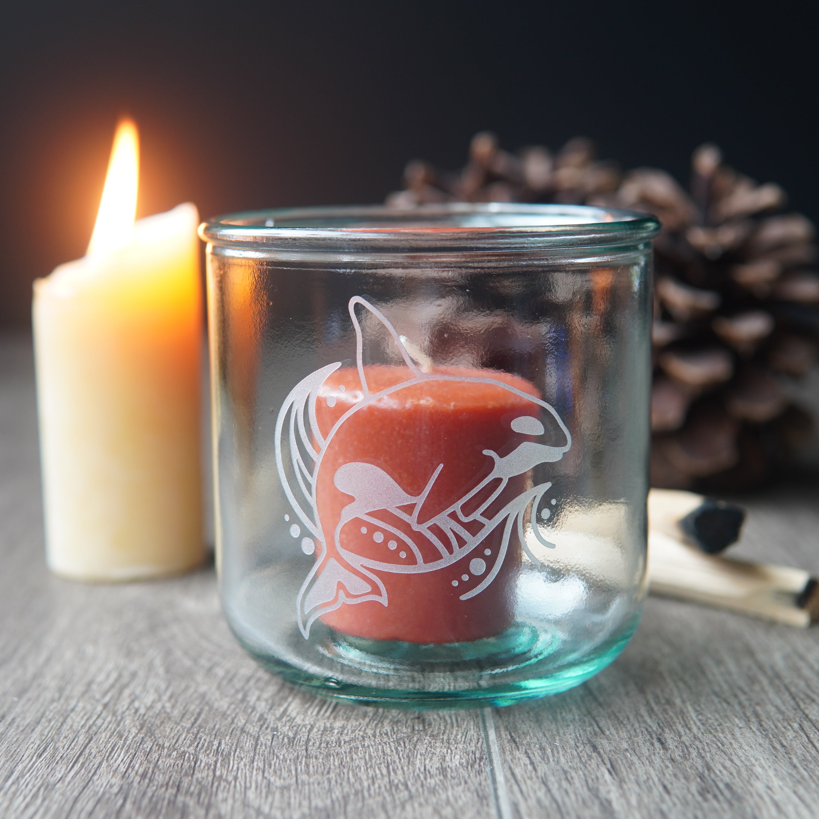 killer whale etched onto a short glass with candles