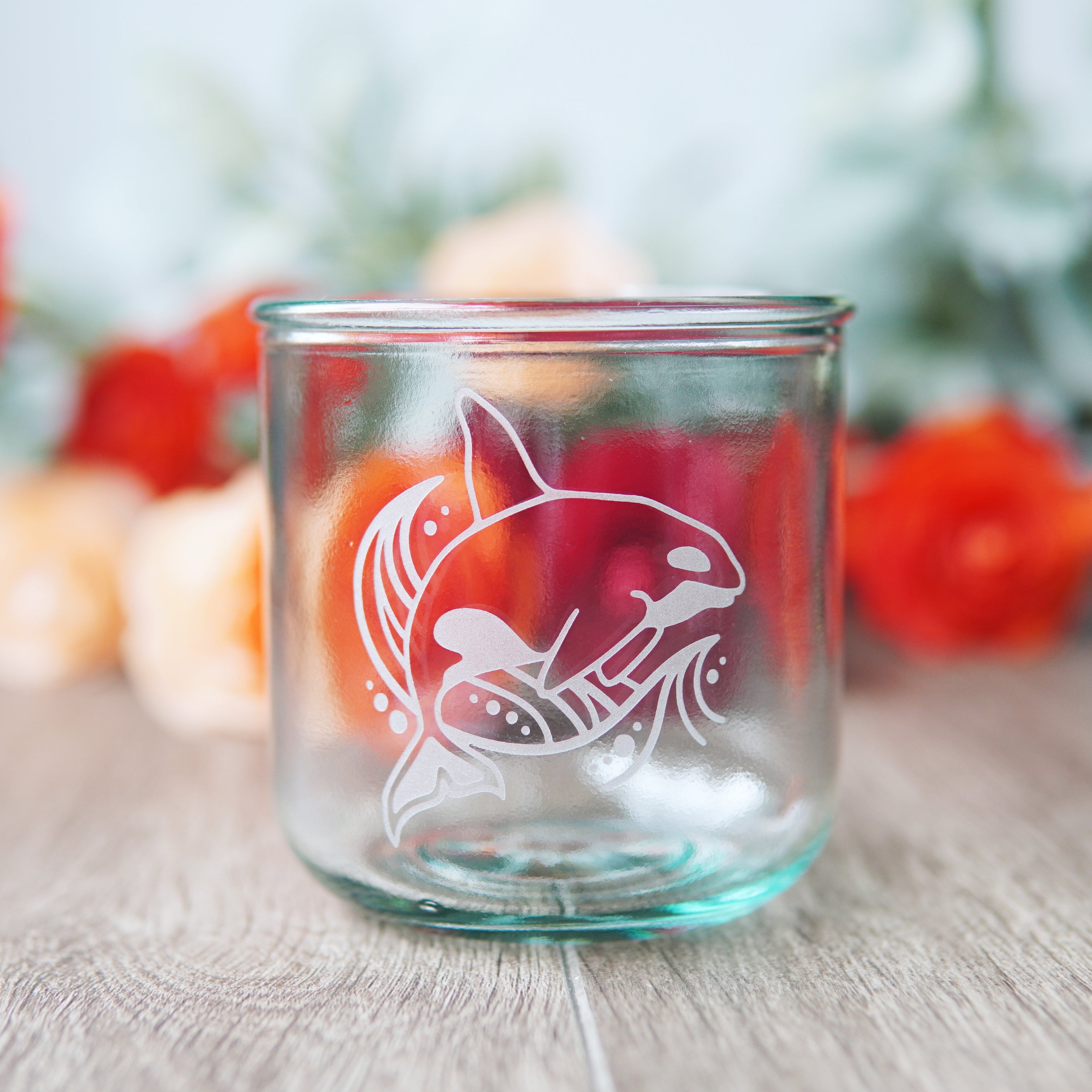 orca whale and stylized waved etched onto a short glass