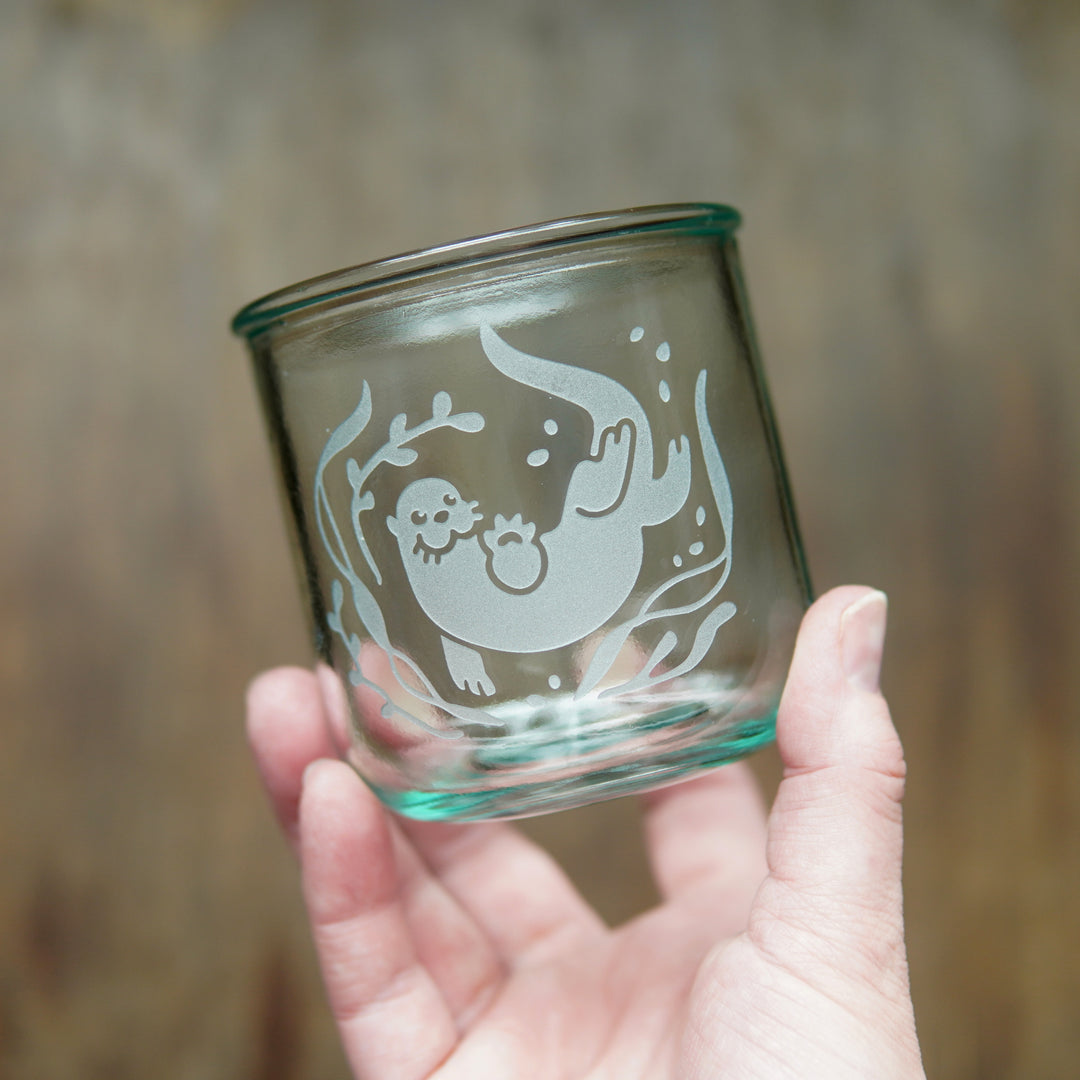 short otter glass held by a hand