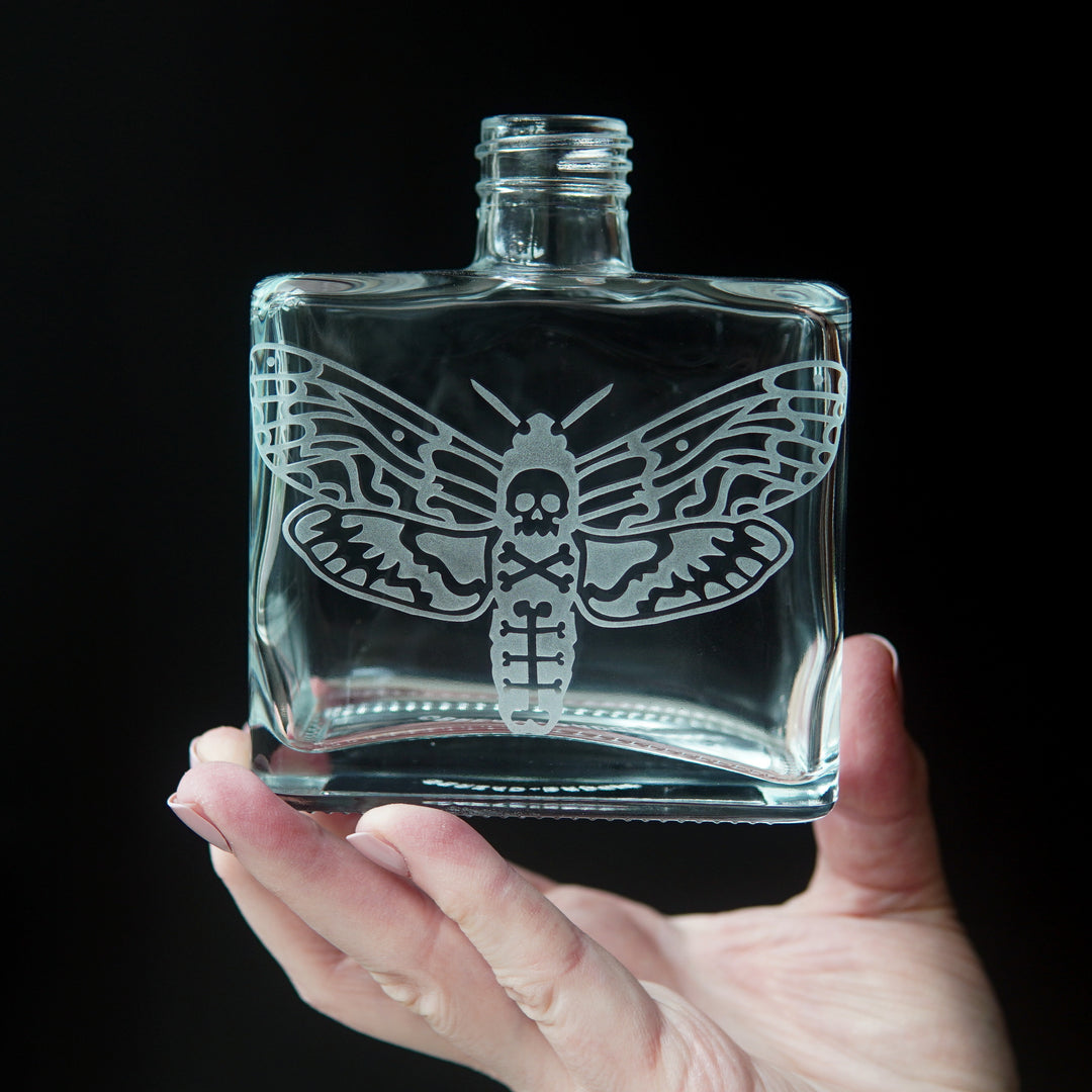 square glass bottle engraved with a deaths head hawkmoth