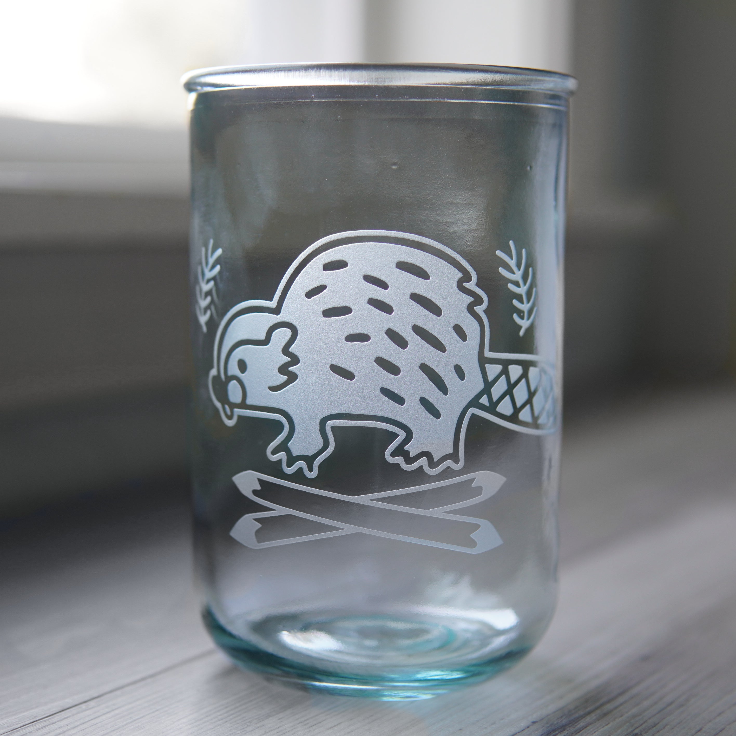 Tall recycled glass cup engraved with a cute beaver and crossed logs
