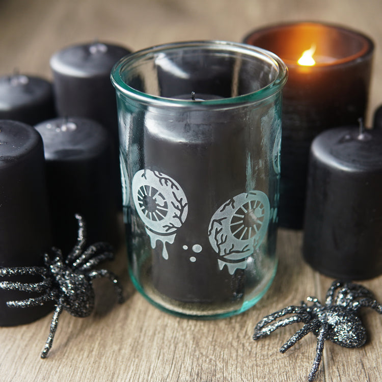 eyeballs tall glass cup with lots of black pillar candles and plastic glittery spiders
