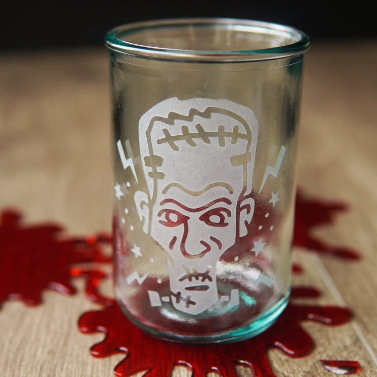 Frankenstein head etched onto a tall glass, sitting on fake blood spatters