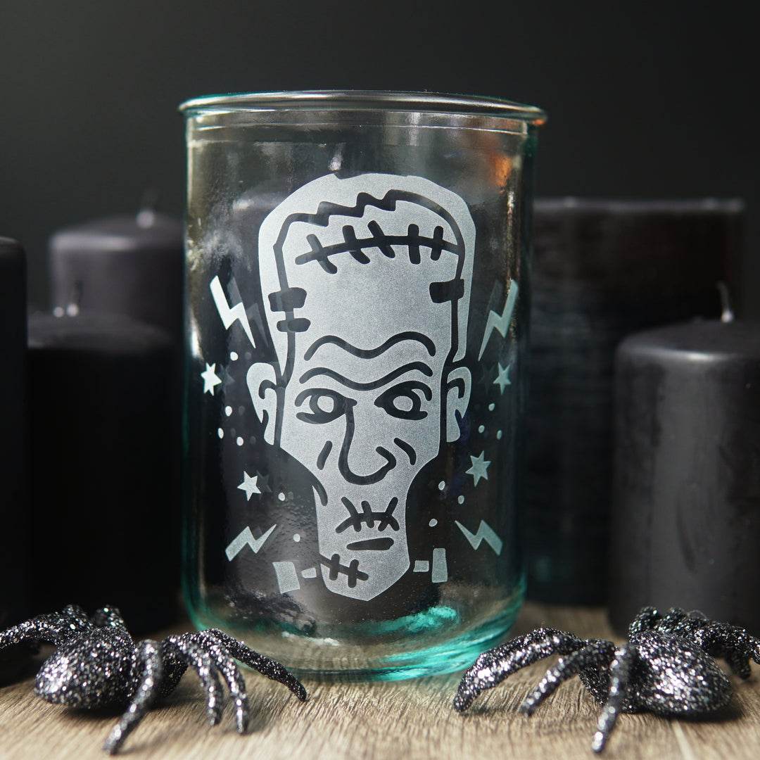 Frankenstein tall glass with black pillar candles and glittery plastic spiders