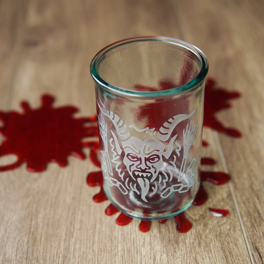 krampus engraved on a tall glass with black fake blood spatters