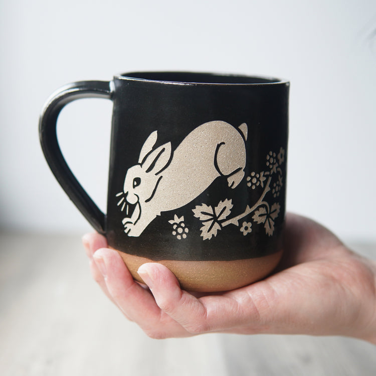 rabbit mug in black, held by a hand