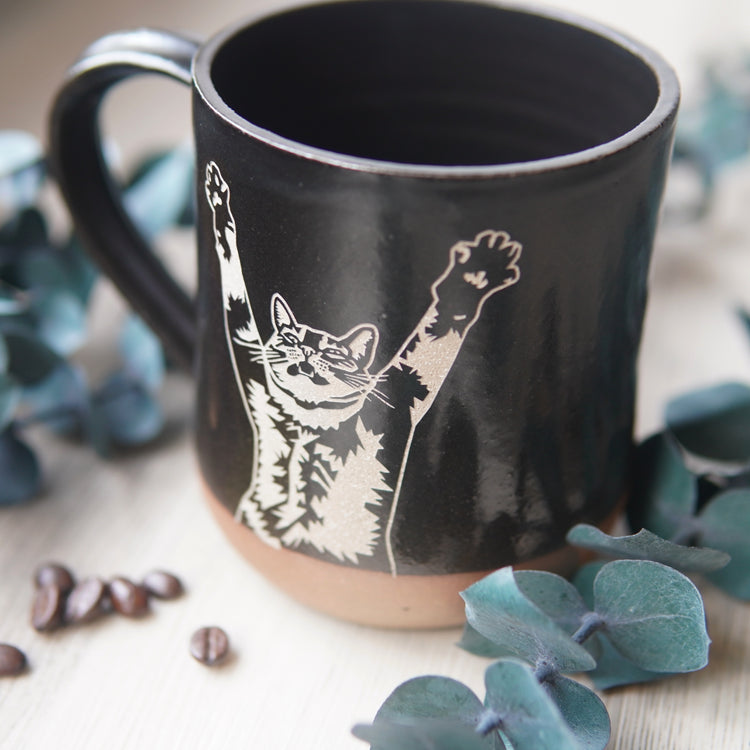 black stretching cat mug