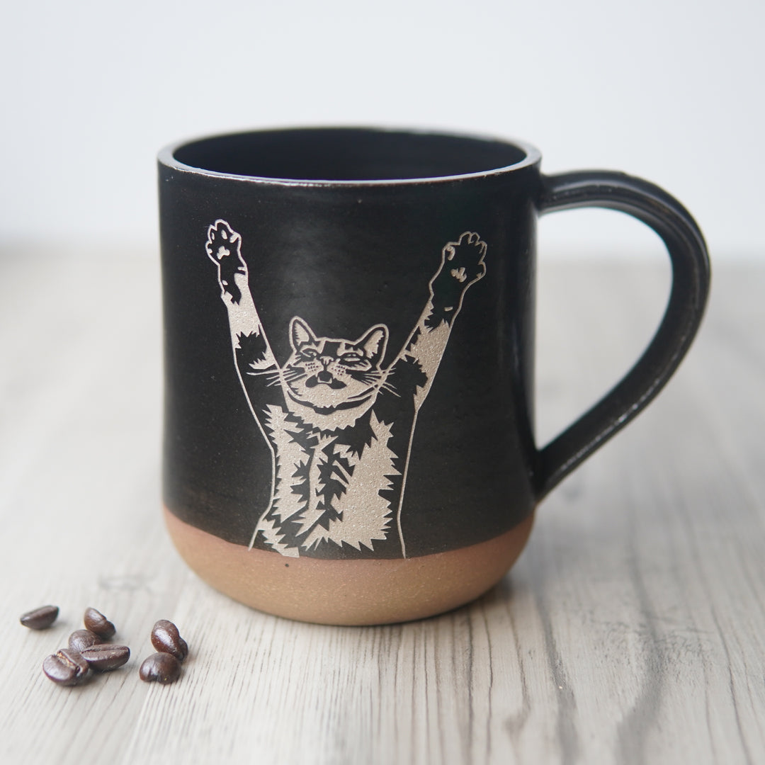 black stretching cat mug