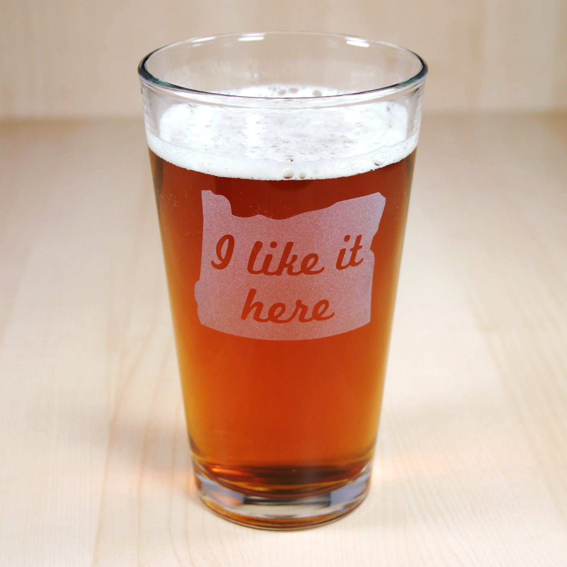 pint glass etched with the state of Oregon and the words "I like it here" inside the state
