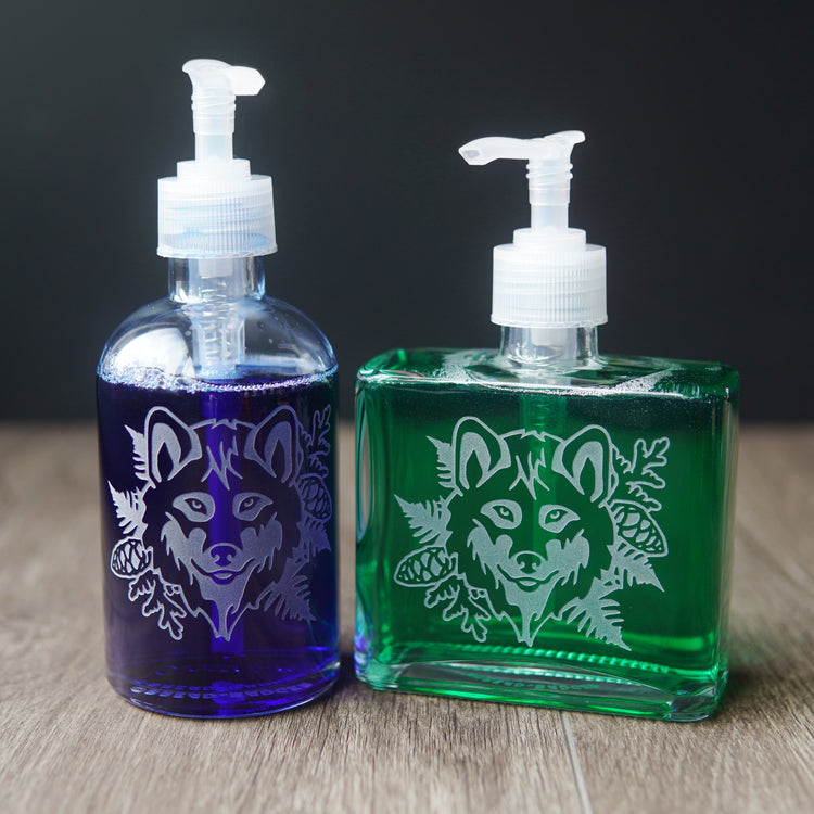 wolf soap dispensers in two shapes, filled with dark colored dish soap