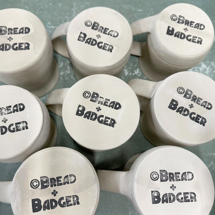 Bread and Badger logo stamped onto the bottoms of handmade mugs