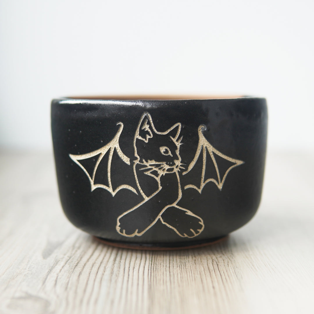 Cat Bat engraved onto a black pottery bowl