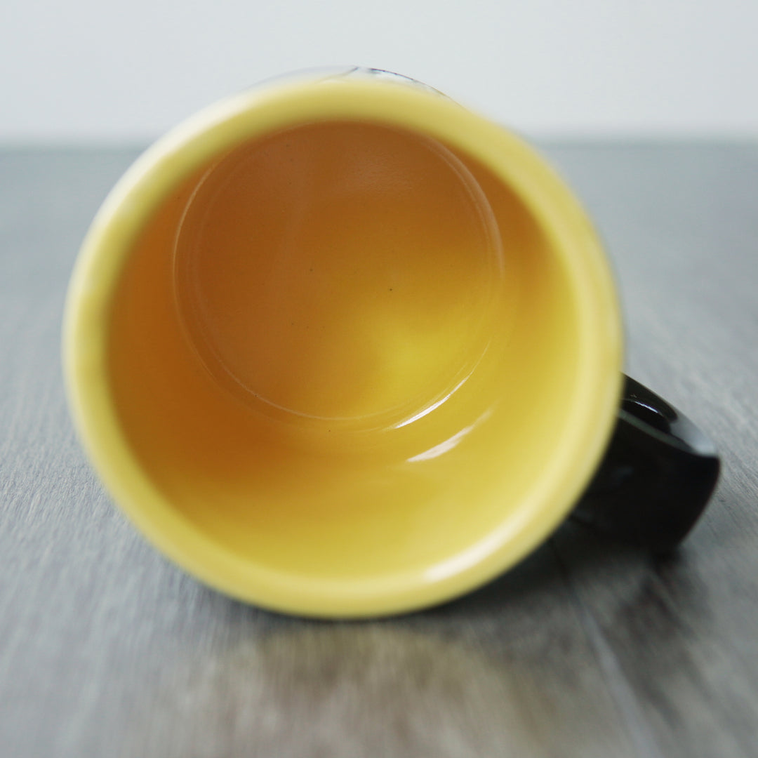Yellow interior of a mug on a wooden surface