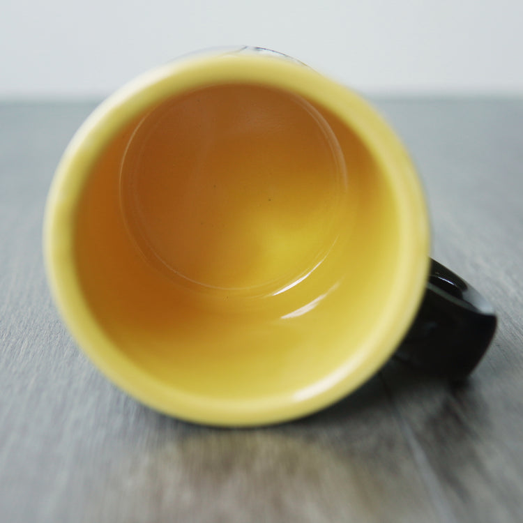 Yellow interior of a mug on a wooden surface
