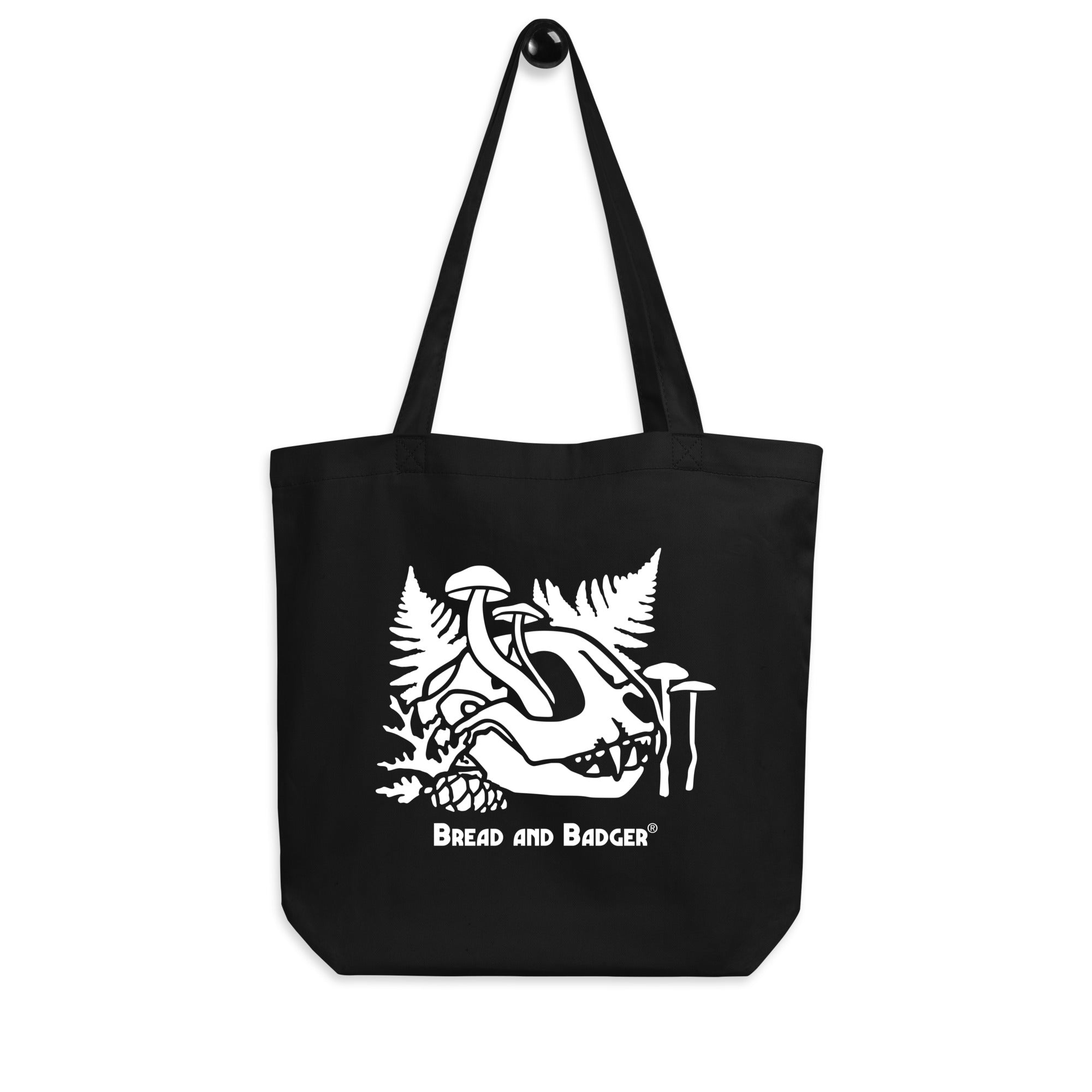 Black tote bag with white cat skull and mushrooms graphic and 'Bread and Badger' text on a white background
