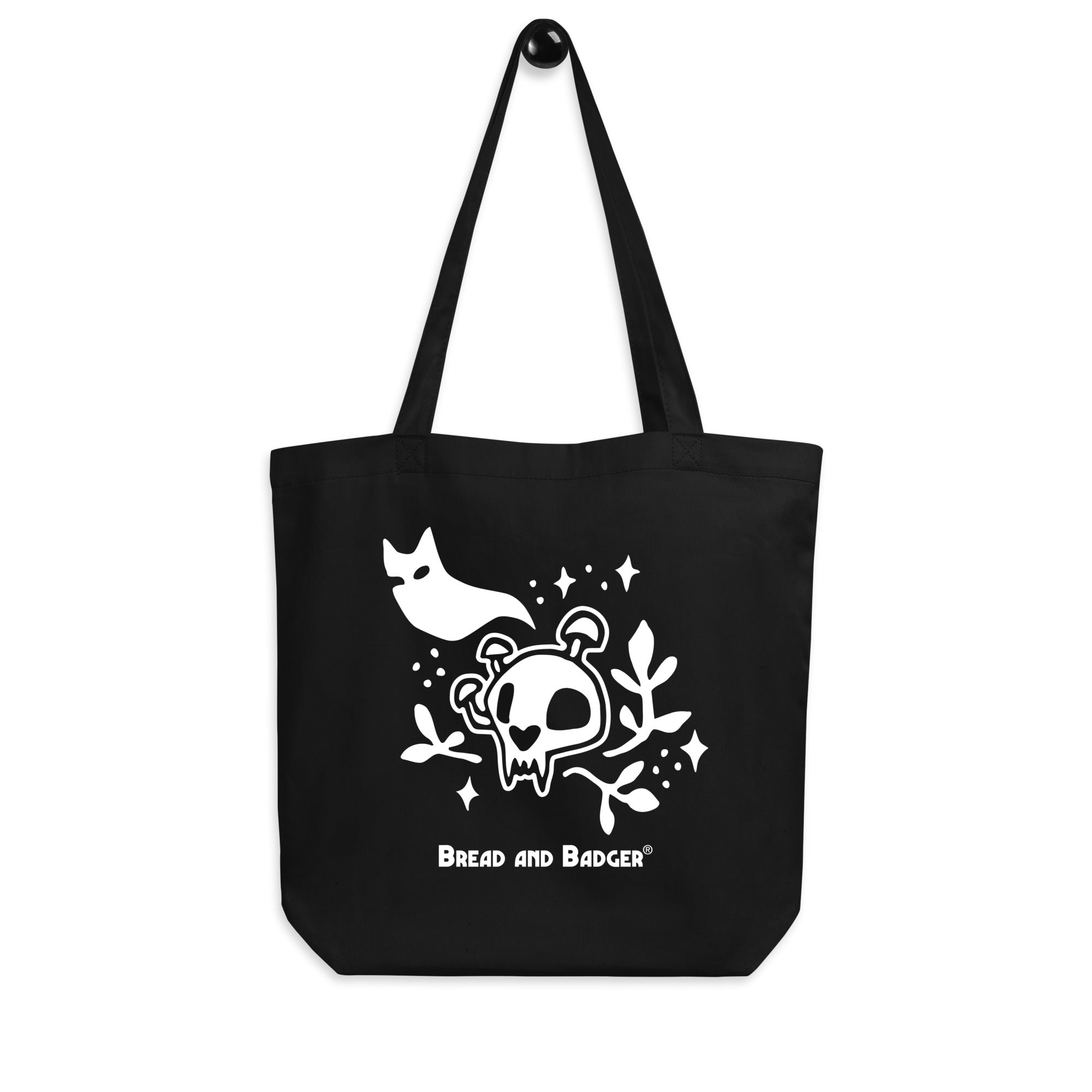 Black tote bag with white skull and cat ghost design and 'Bread and Badger' logo.