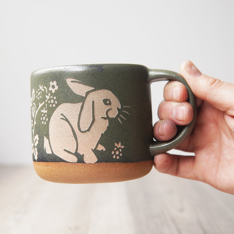 Rabbit Mug in Moss green, held in a hand