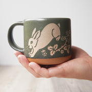 Rabbit Mug in Moss green, held in a hand