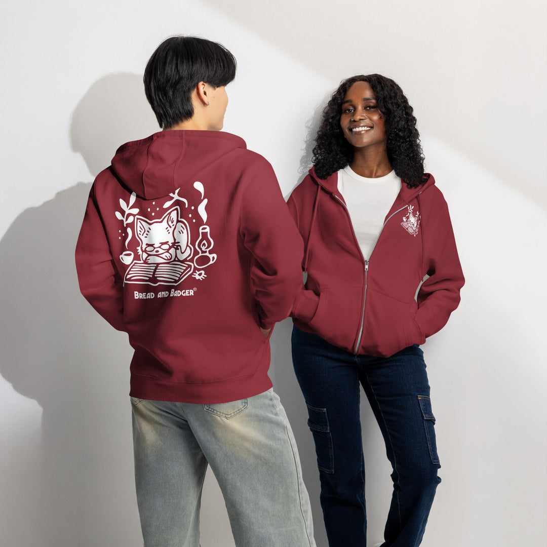 Two people wearing burgundy hoodies with white graphics on a plain background
