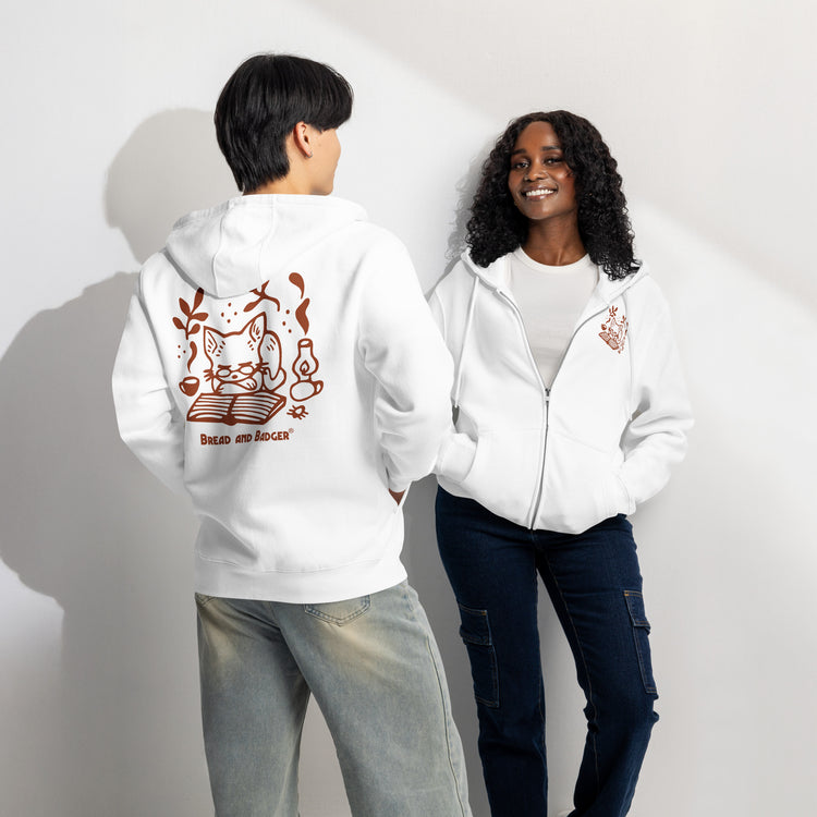 Two people wearing white hoodies with rust-red graphics on a plain background