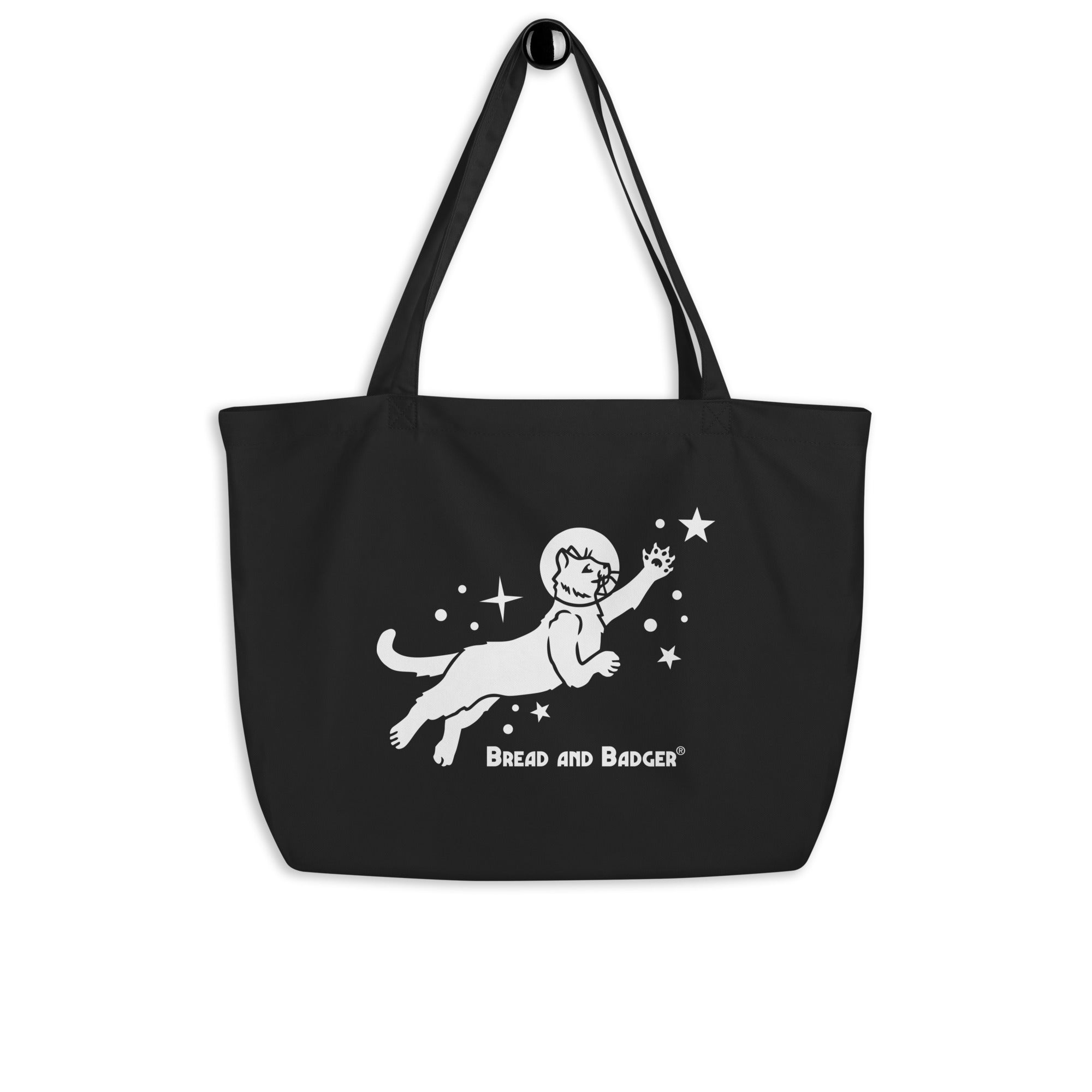 Black tote bag with white astronaut cat graphic and 'Bread and Badger' text on a white background