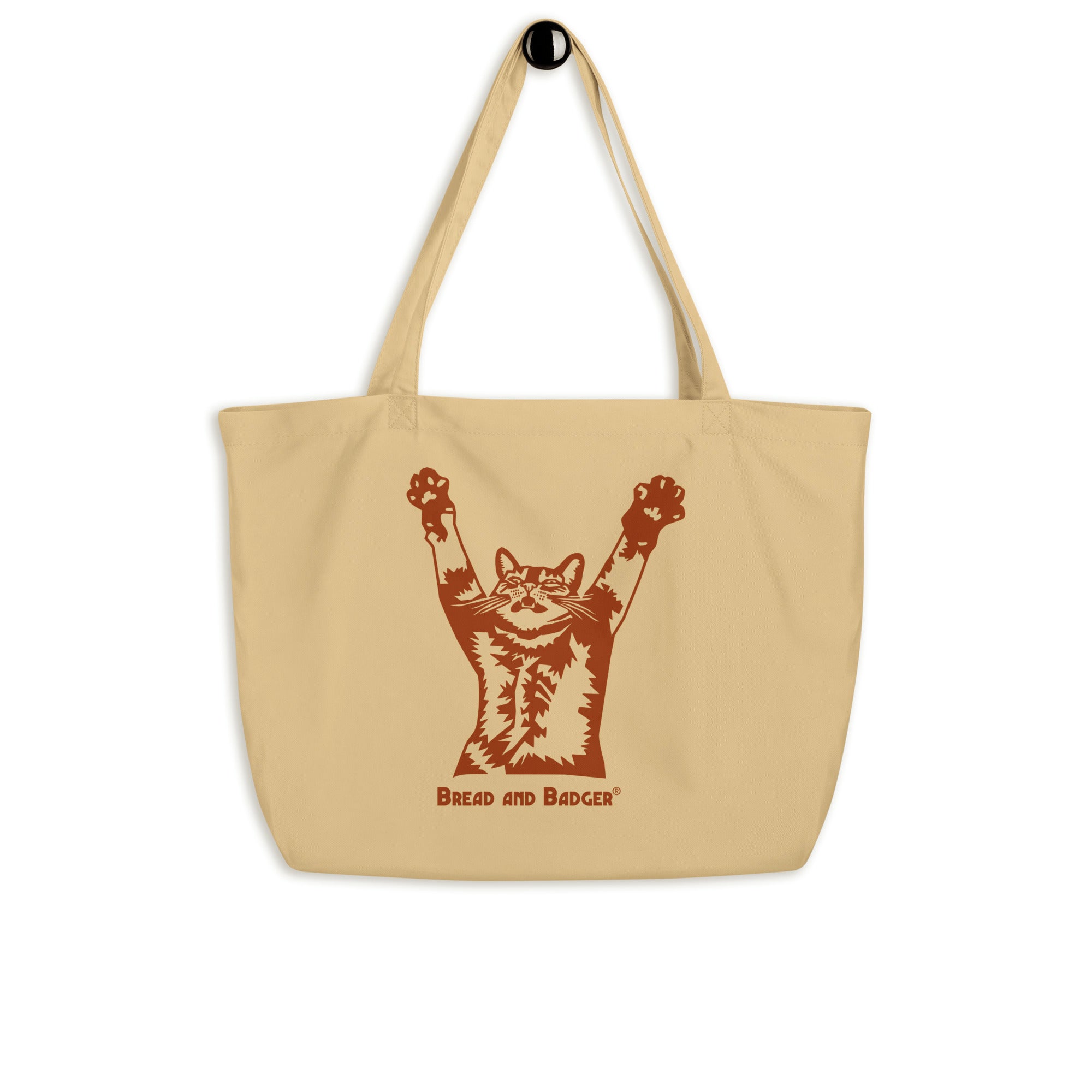 Beige tote bag with a brown graphic of a cat and text on a white background