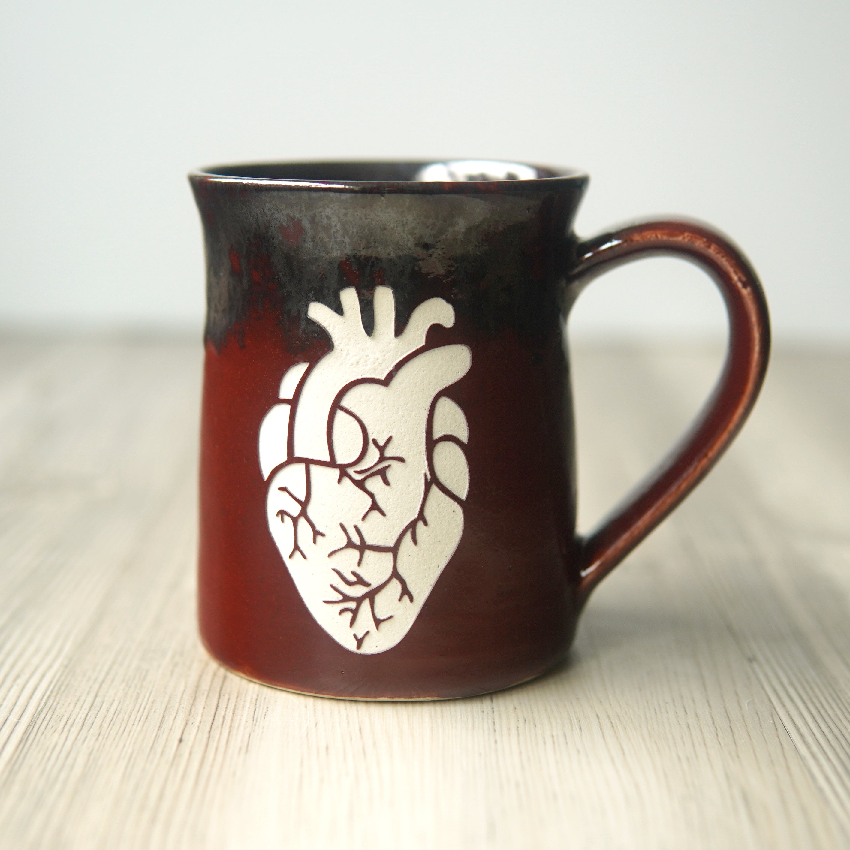 anatomical heart engraved on a red and dark gray mug