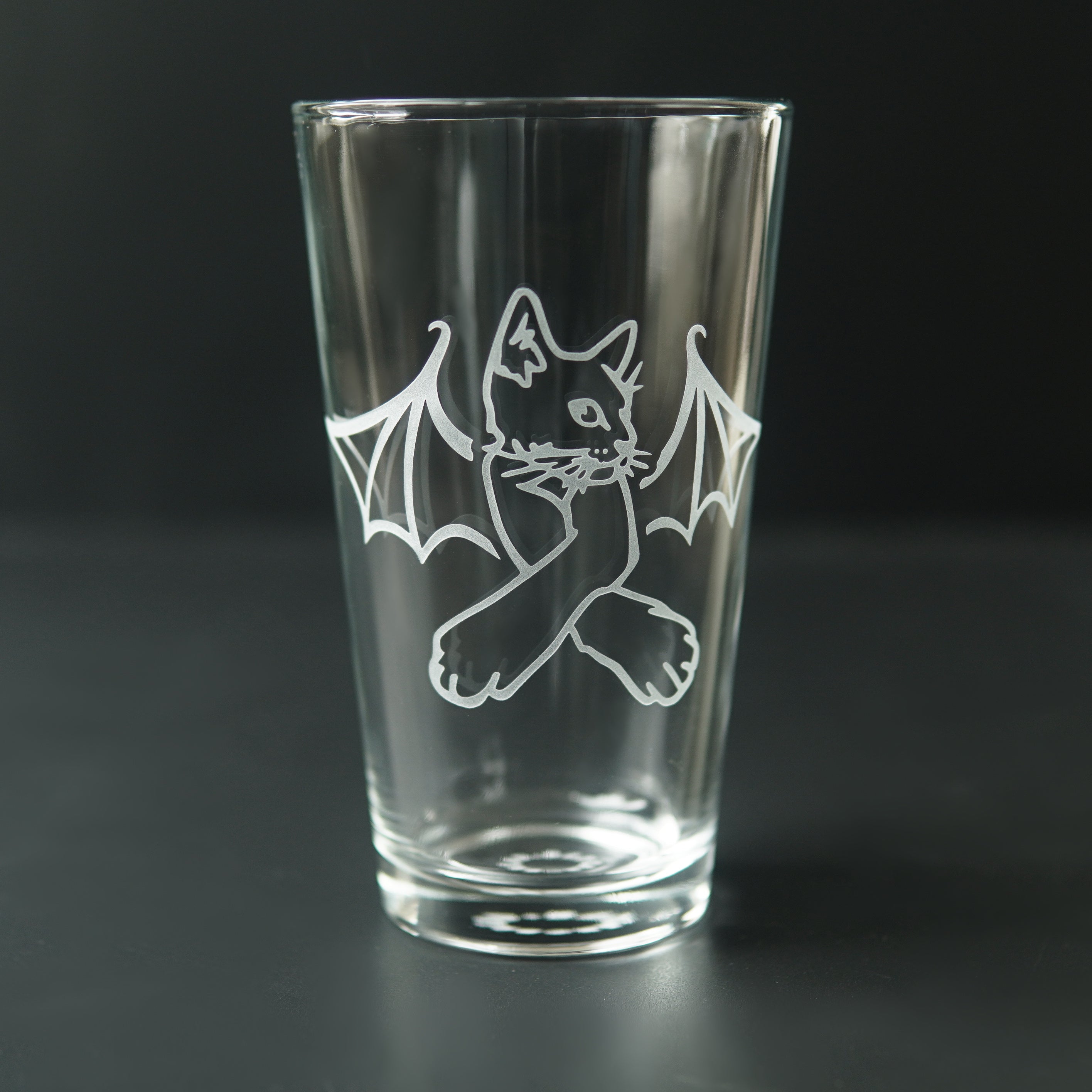 pint glass engraved with a cat with bat wings