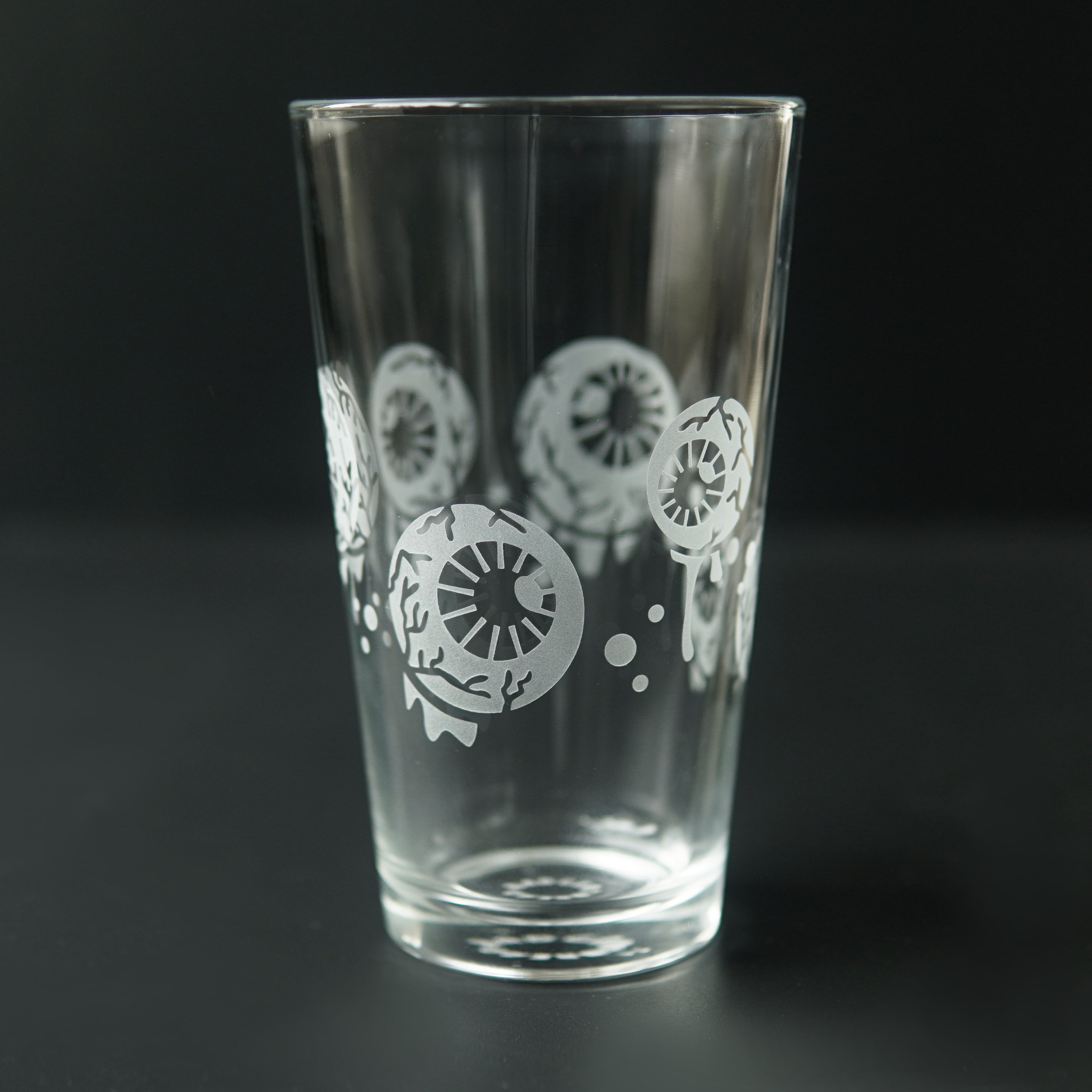 Pint glass engraved with dripping eyeballs all around it