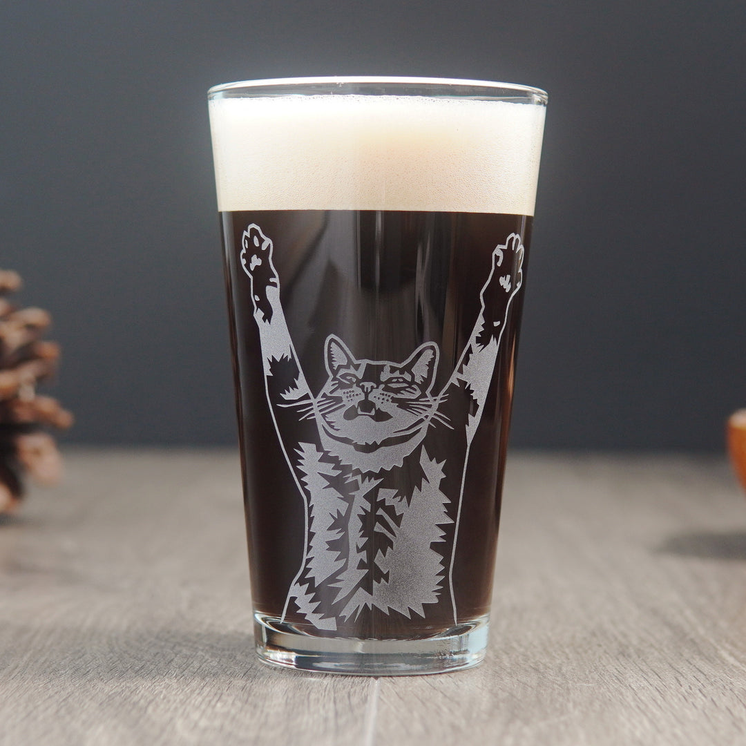 pint glass etched with the upper half of a tabby cat whose arms are raised and its mouth is open partially