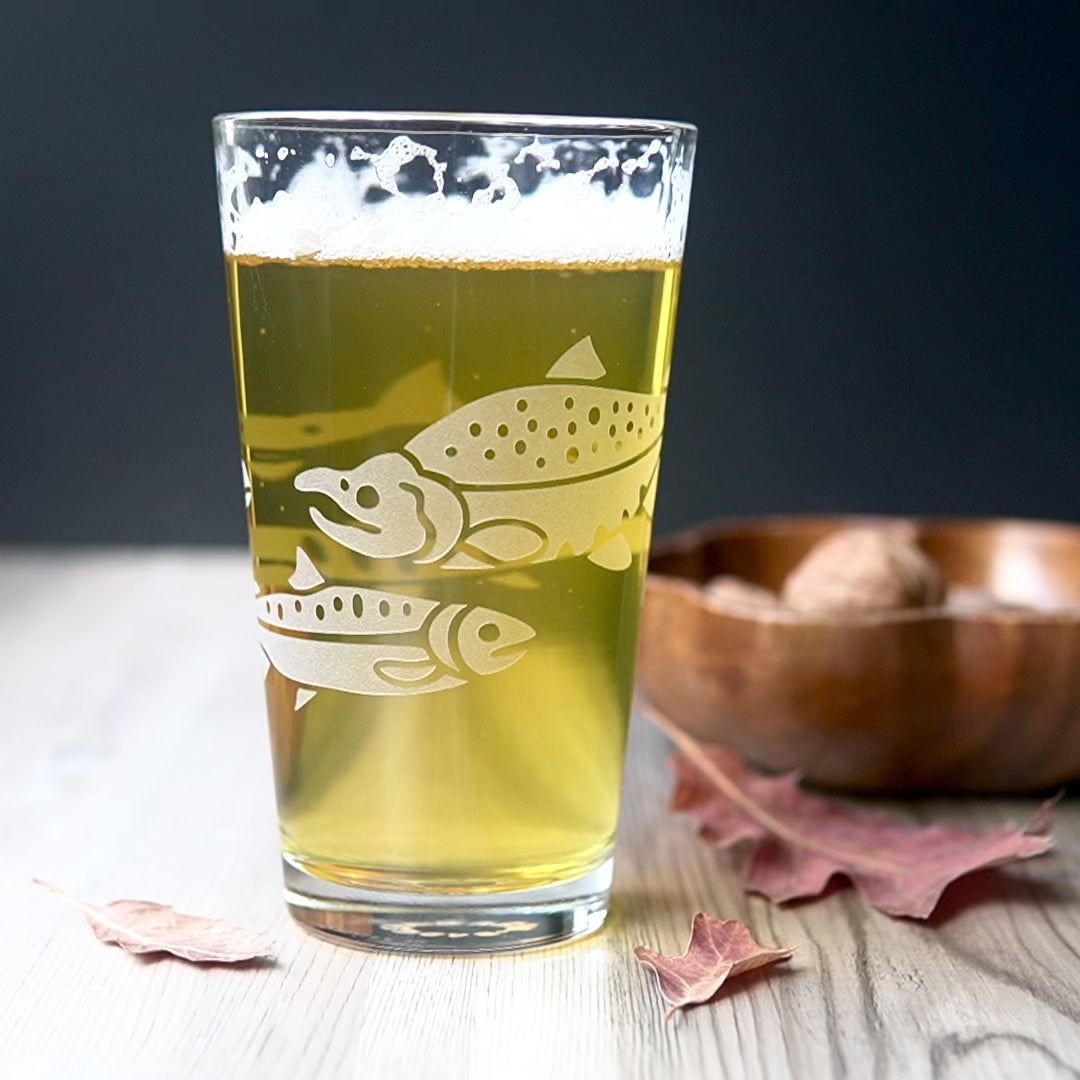 video of a Salmon pint glass full of yellow beer, being rotated by a hand to show all sides of the design